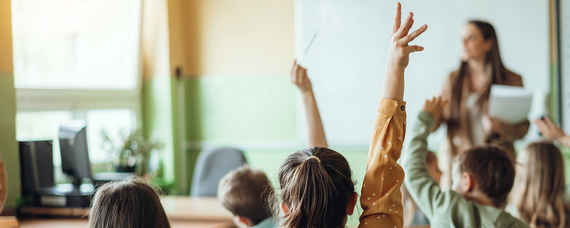 Student raising her hand in a classroom