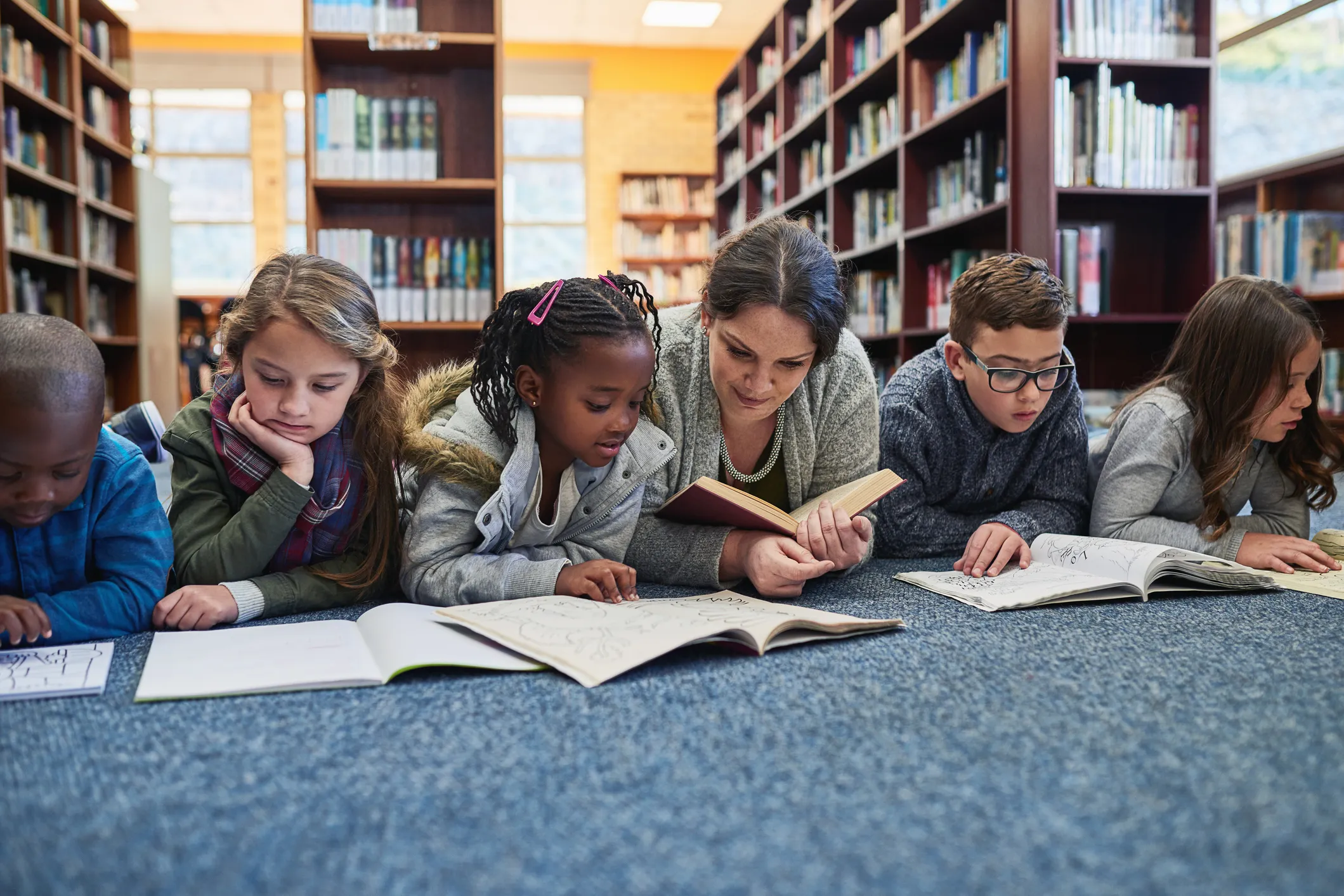 Children reading on the floor of a library
