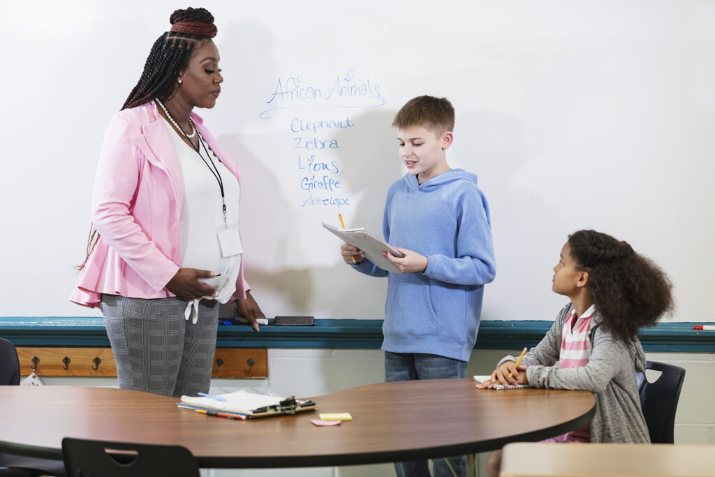 teacher helping students in classroom