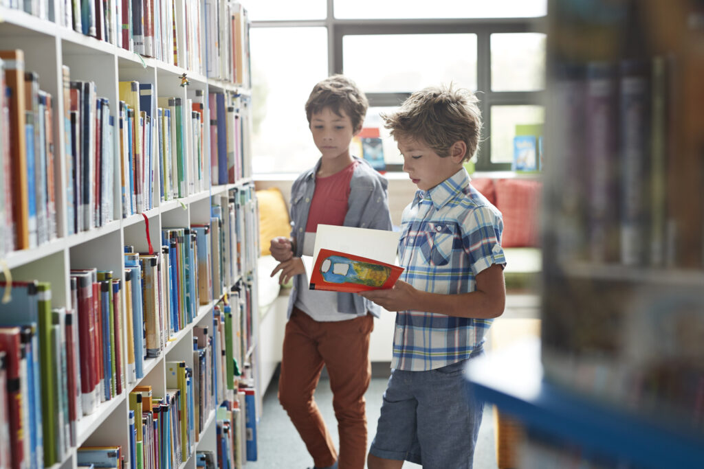 boys looking at books in library