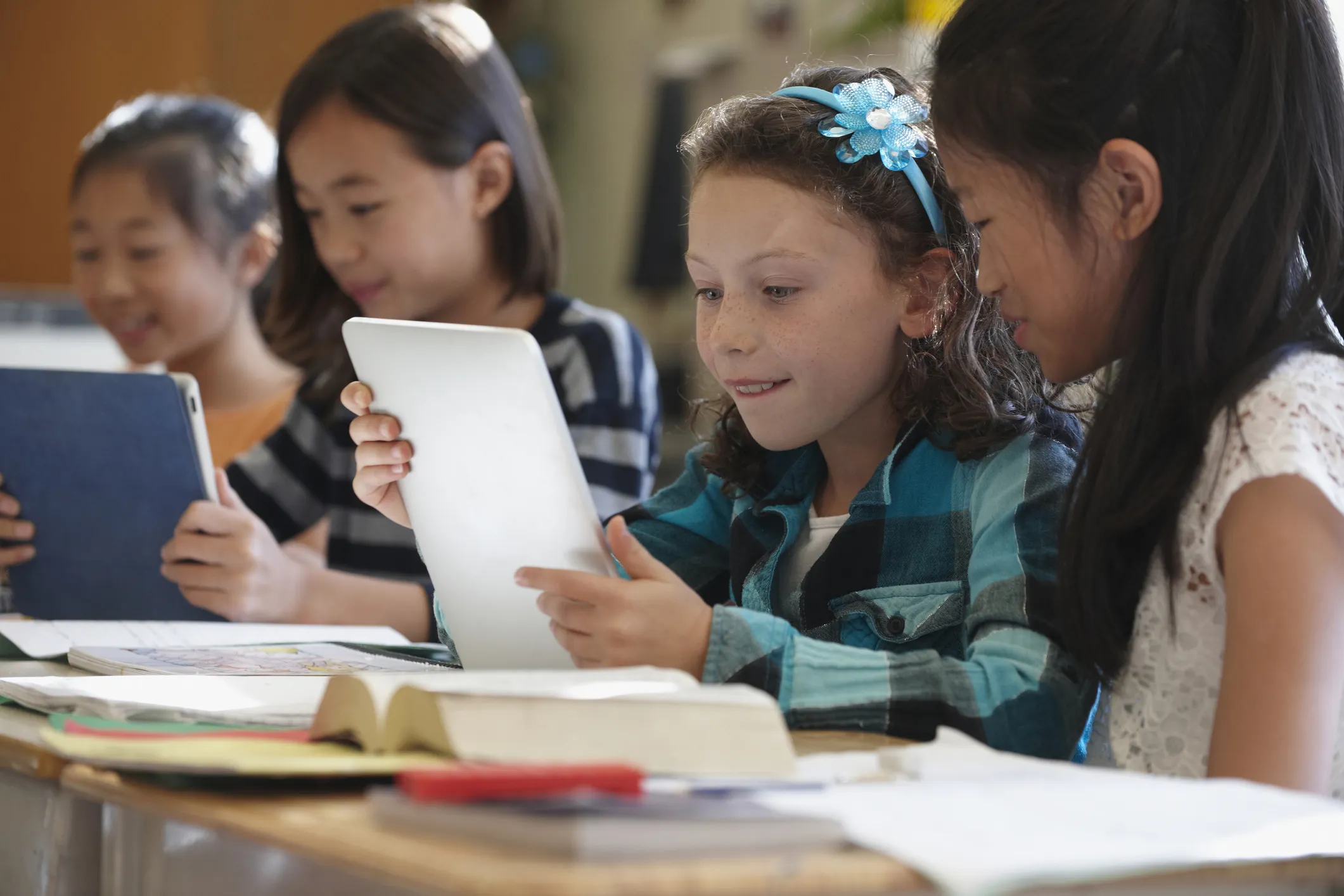 Students at a desk looking over classwork