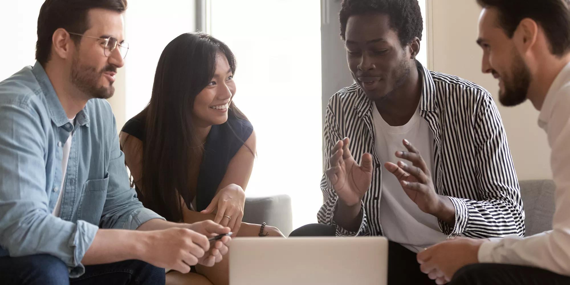 Adults talking around a laptop computer