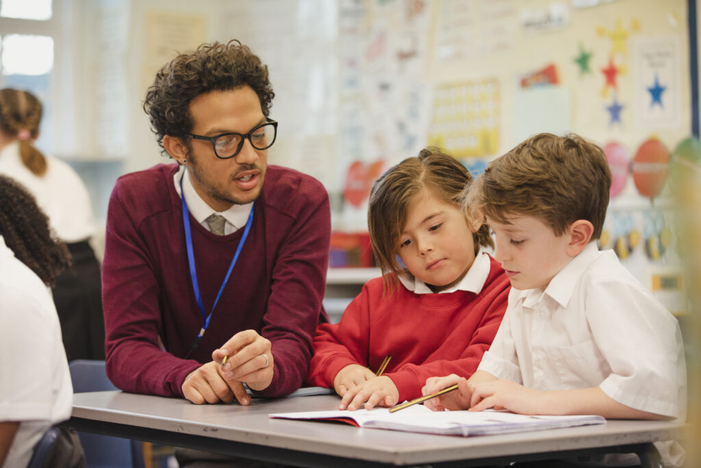 teacher helping young students