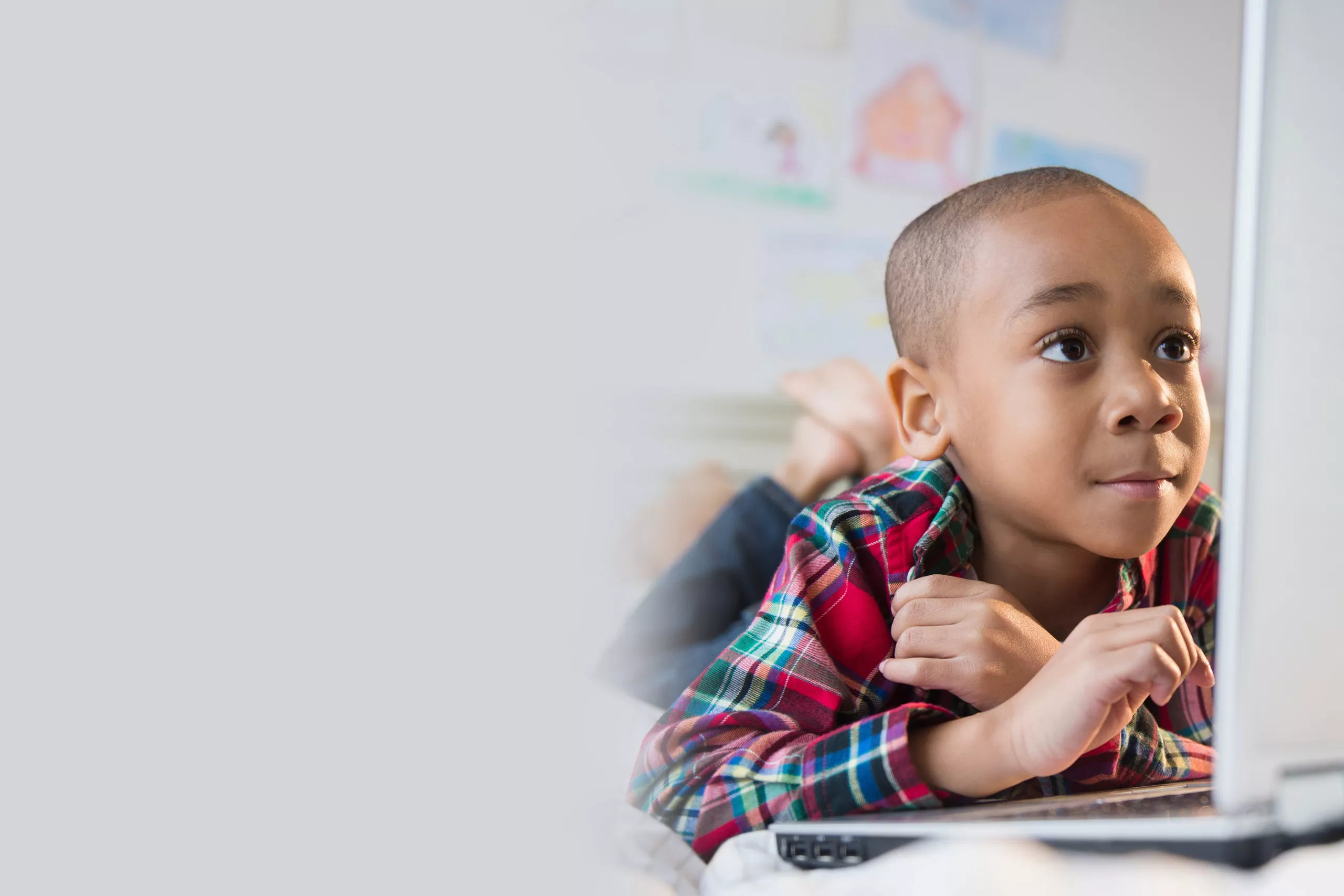 Young boy looks at a computer screen.