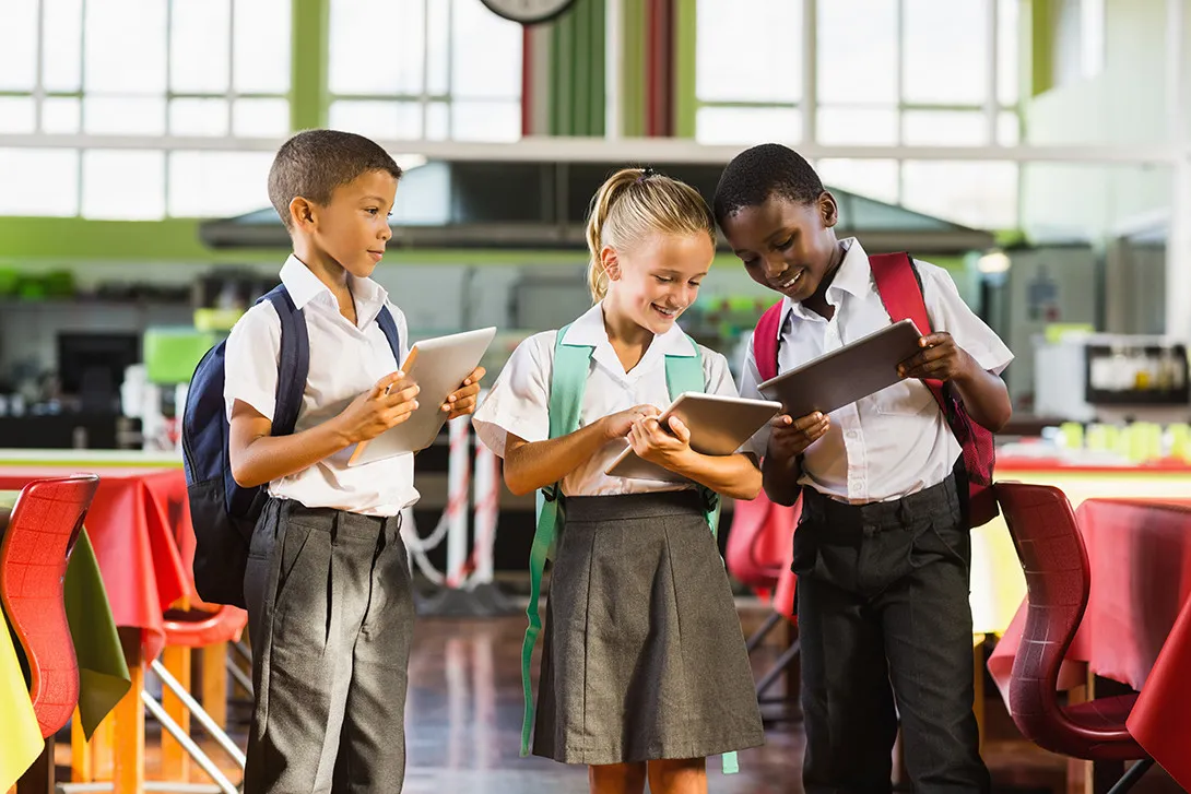 Students look at tablets while standing 