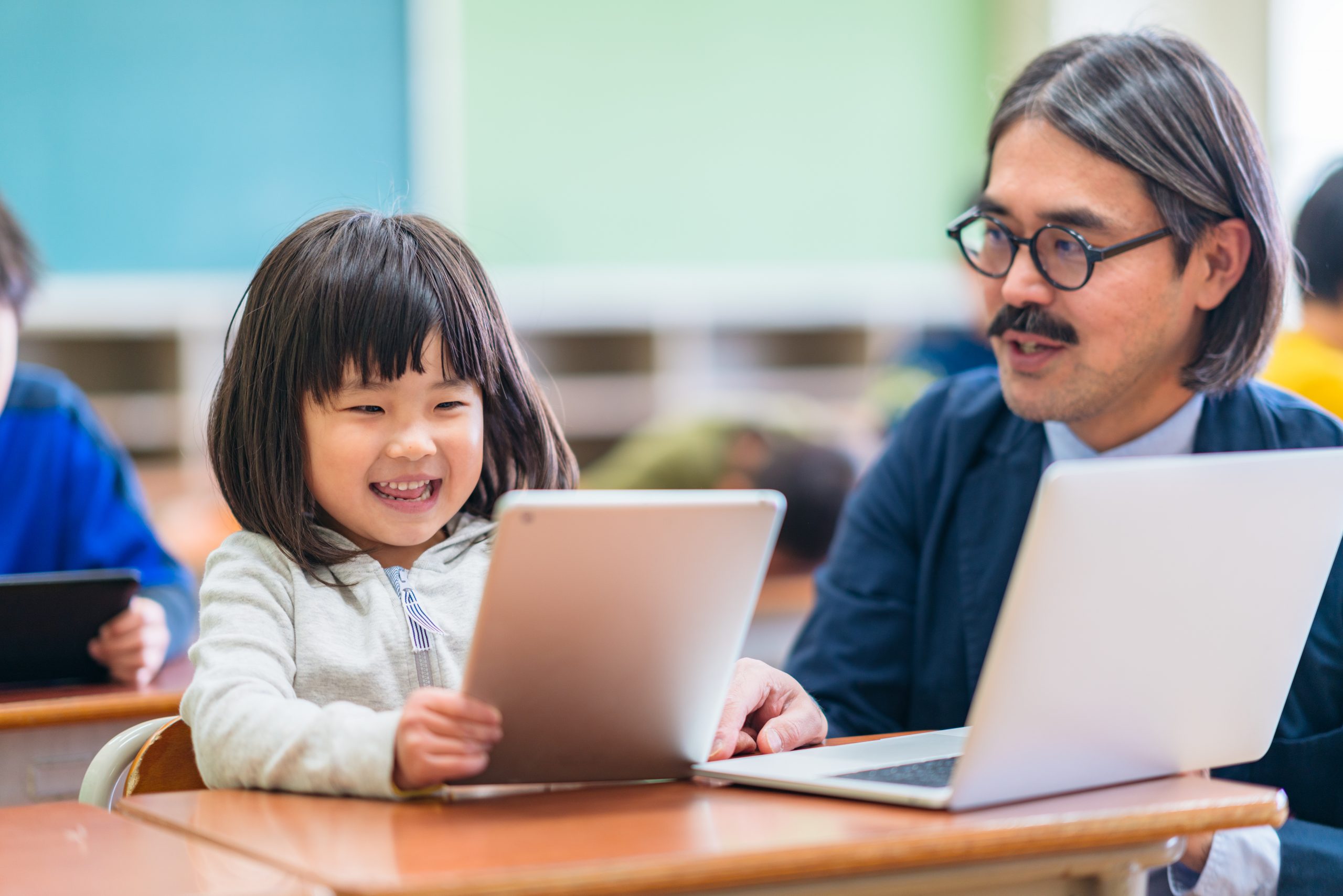 child and teacher with tablet