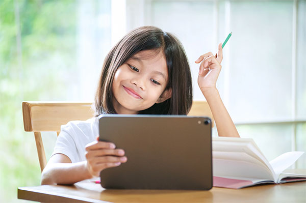 Girl smiling while on her tablet