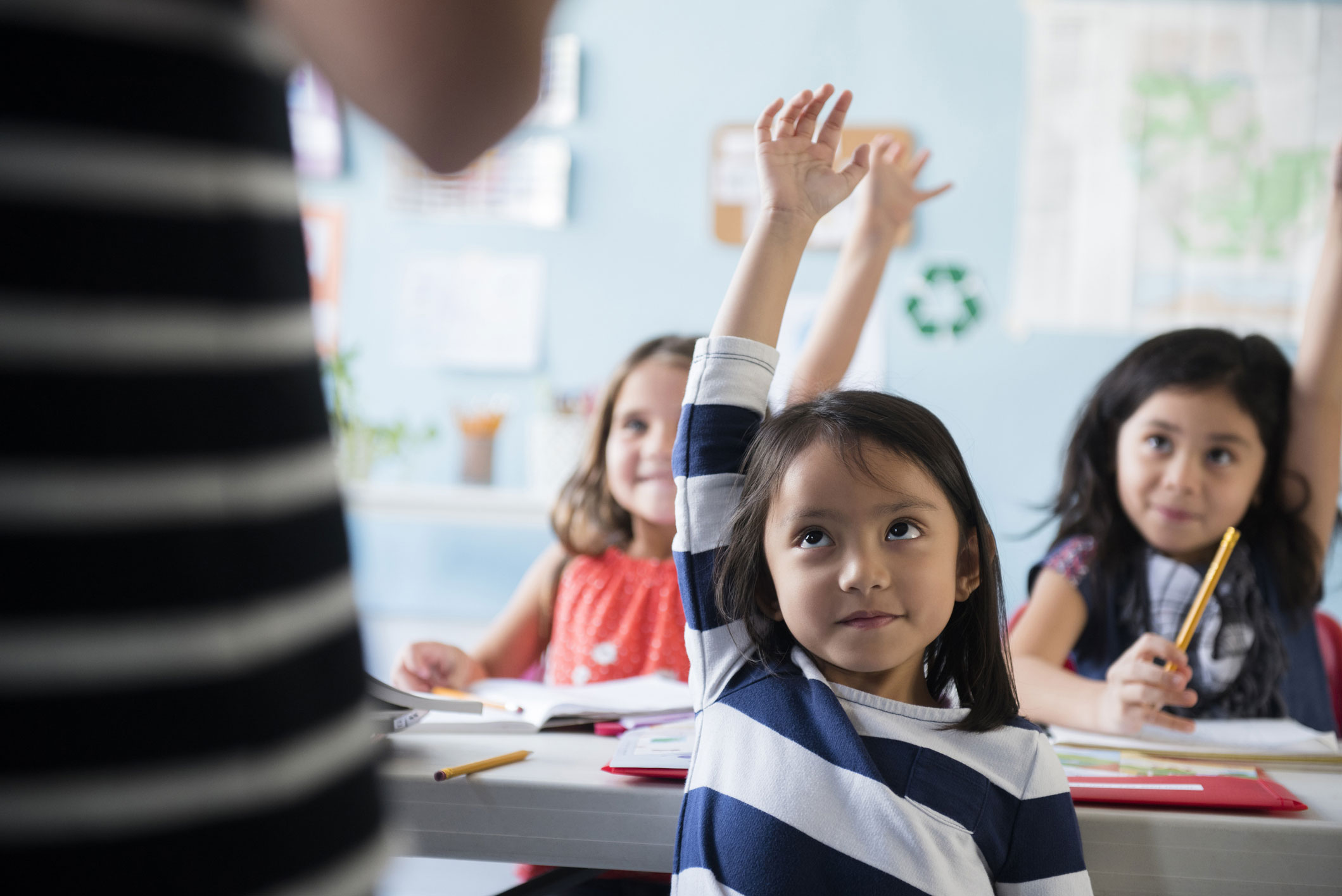 girl raising hand in classroom