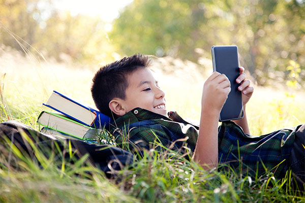 Boy in grass with tablet