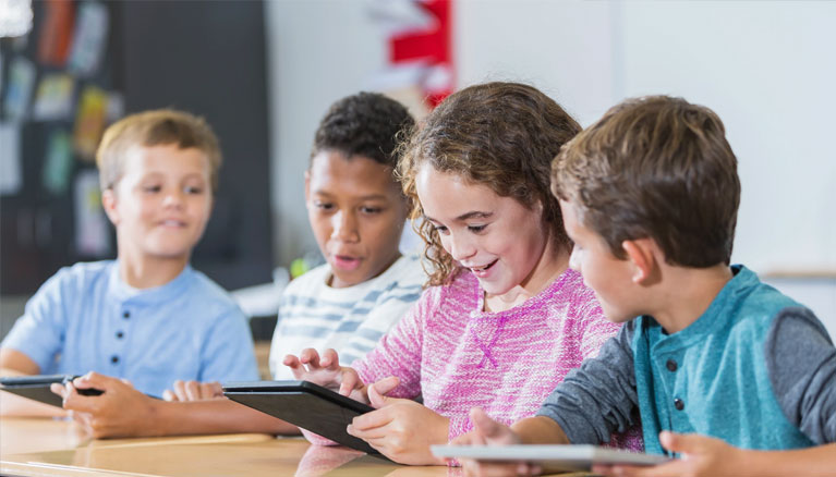 4 students reading in a classroom