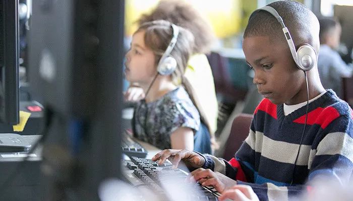 boy typing with headphones