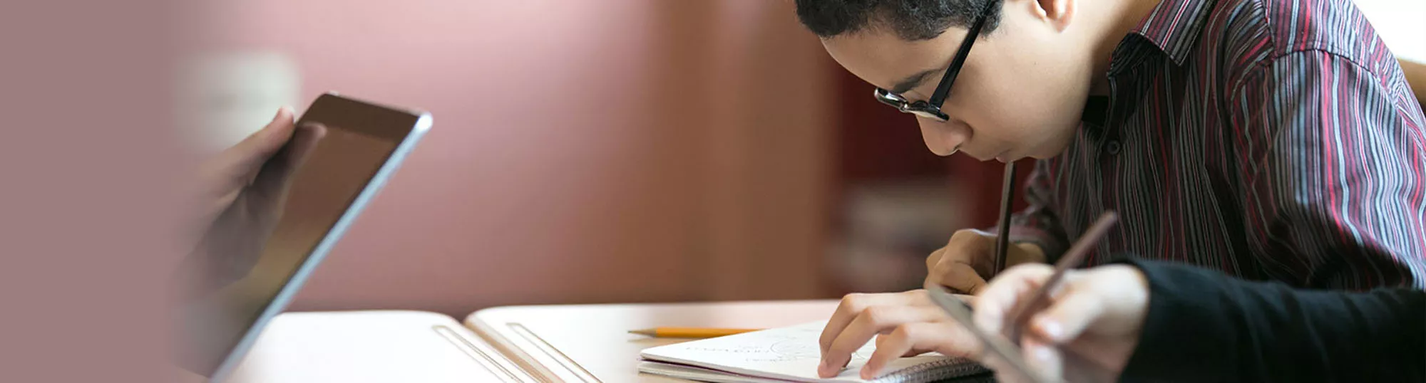student writing with open laptop