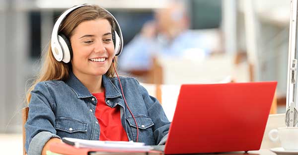 Smiling teen girl on red laptop