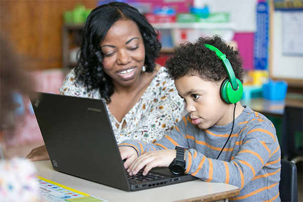 Teacher and boy on laptop