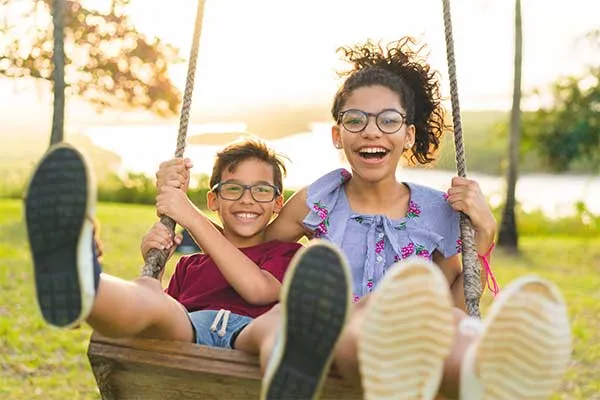 two kids on a swing