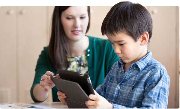 Teacher and young boy with tablet.
