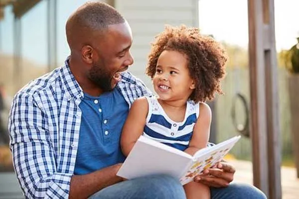 father reading with child outdoors
