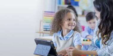 kids working with teacher on tablet