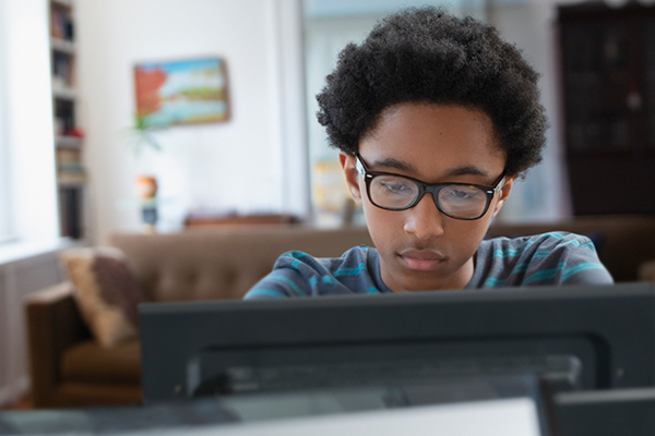 Boy in glasses on a computer