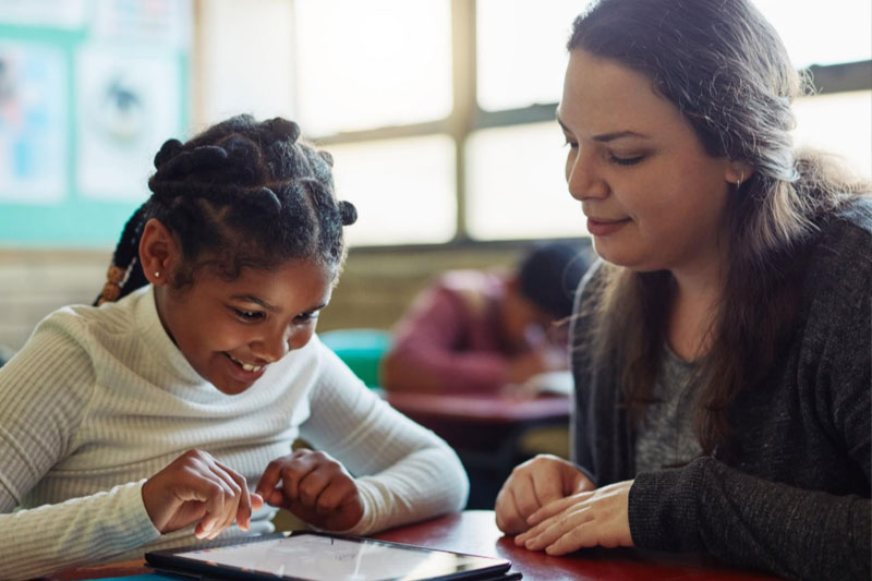 Teacher with student on tablet