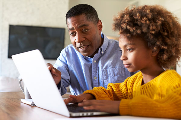 Teacher with girl on laptop