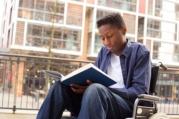 Boy reading in wheelchair