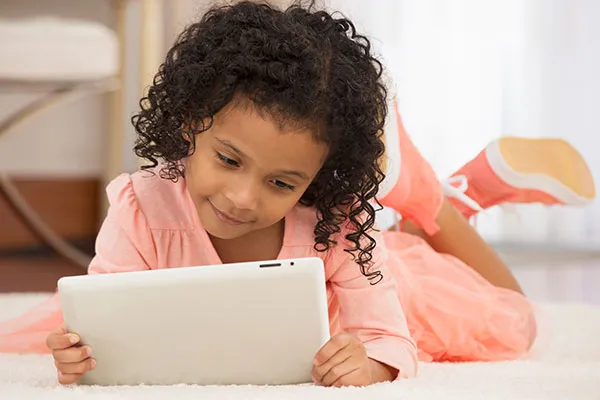 Little girl in peach with tablet