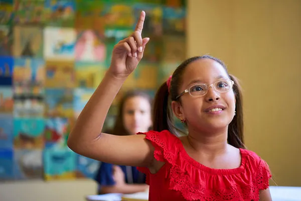 A girl raising her hand in a classroom