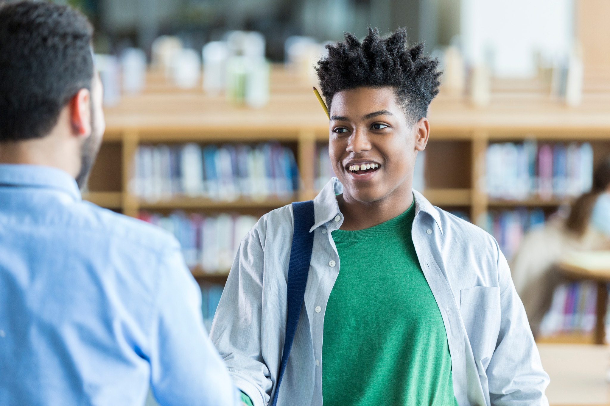 teen boy talking to teacher