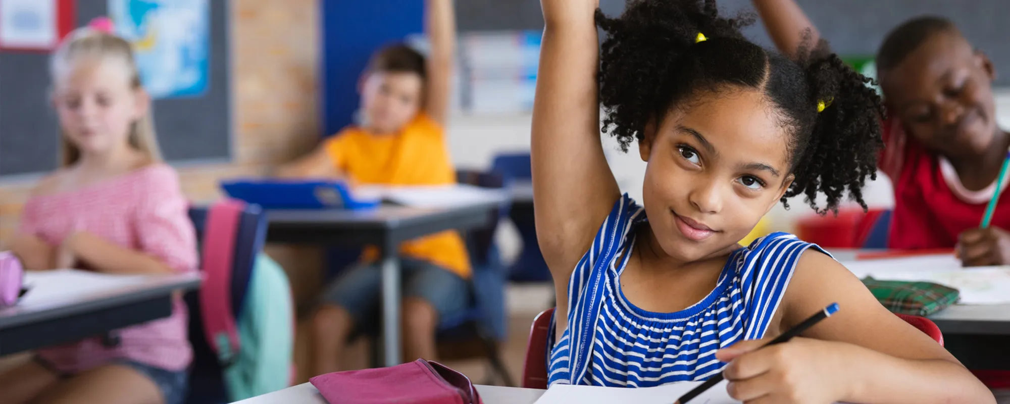 kids raising their hands in class