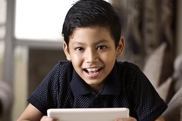 Smiling male student holding a tablet