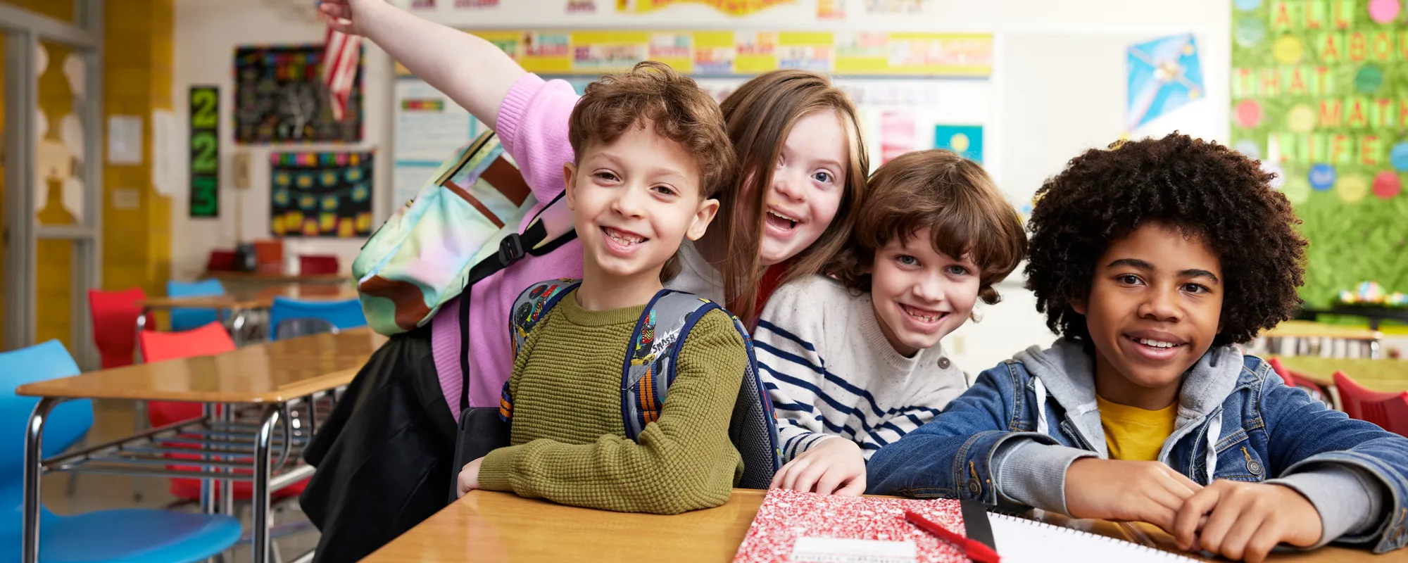 group of kids huddled up by desk