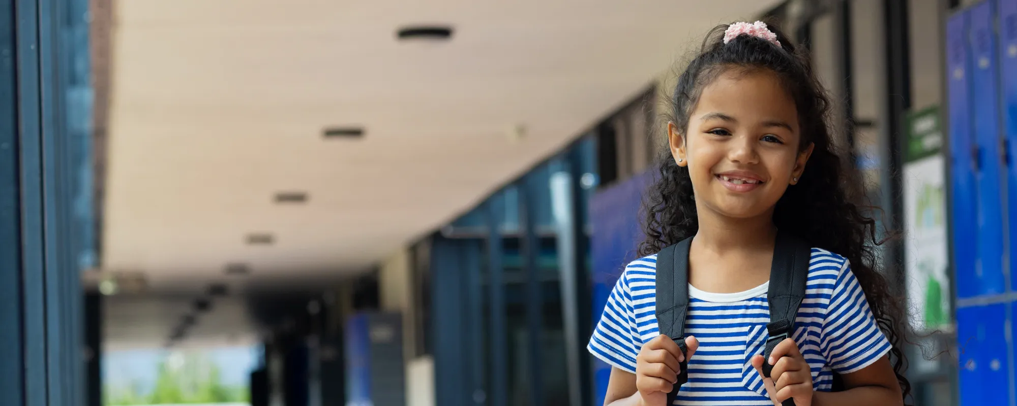 hispanic child in outdoor school looking at viewer