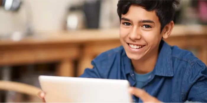 smiling student holding tablet