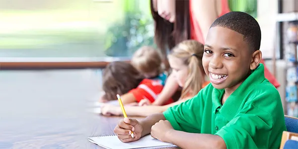 A boy at a desk in a classroom