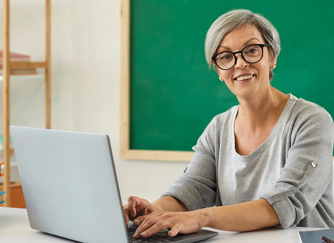 Administrator in a classroom on a laptop collecting data