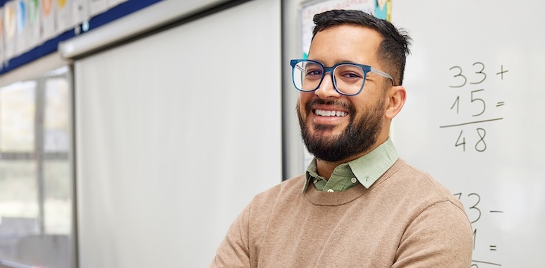 a male math teacher with fractions on a white board smiling