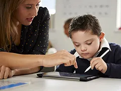 Boy and teacher using a tablet computer