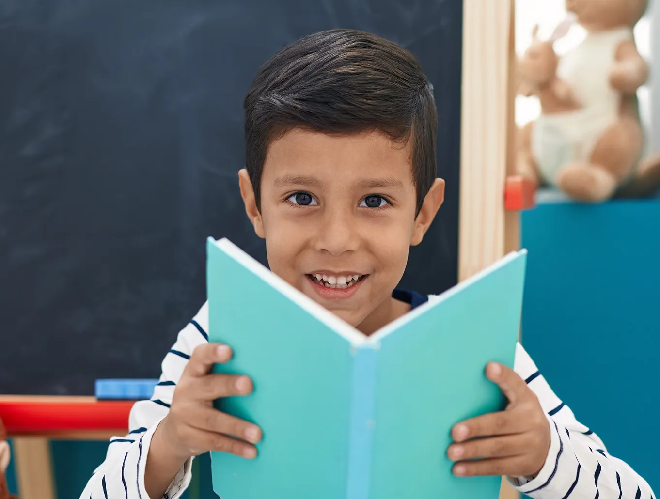 Star Alfabetización temprana student holding a book smiling