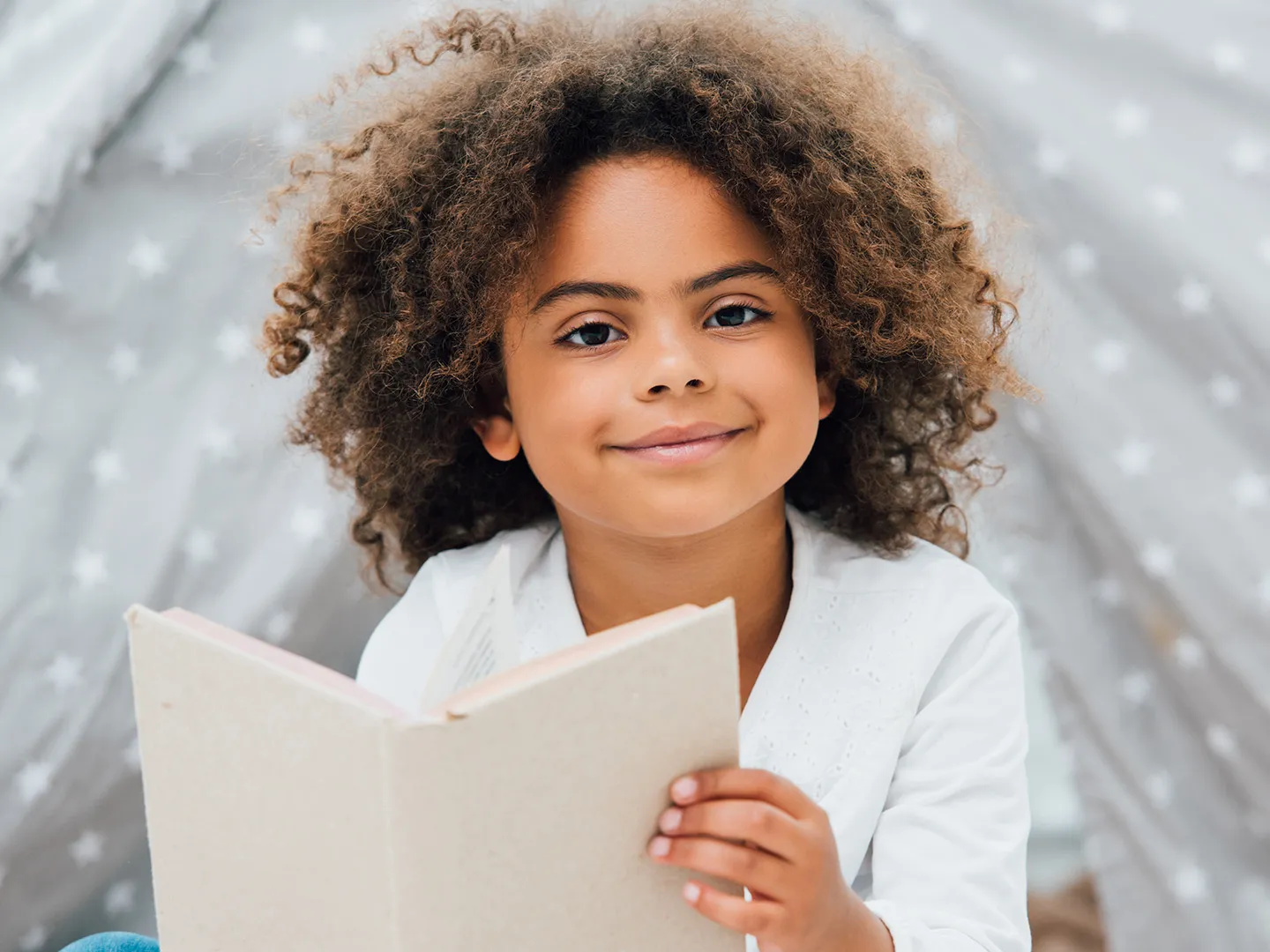 a girl with a book smiling