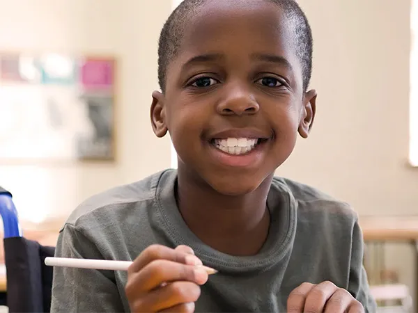 A young boy at a desk in a classroom